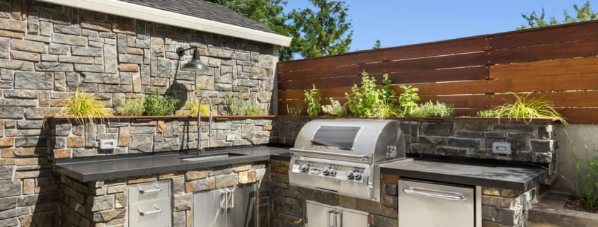 Backyard hardscape patio with outdoor barbecue and kitchen
